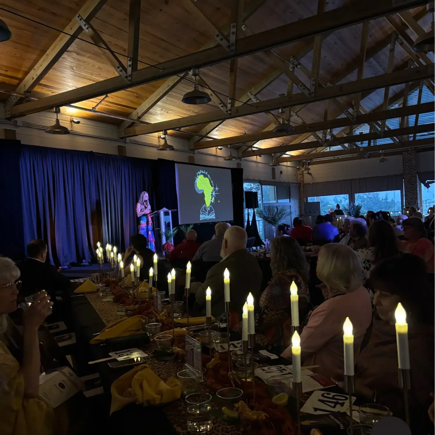 Guests seated at candlelit tables for a World Book Day event